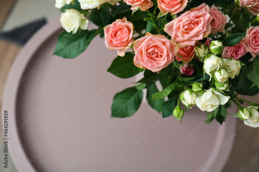 Bouquet of beautiful fresh roses on table in room, closeup