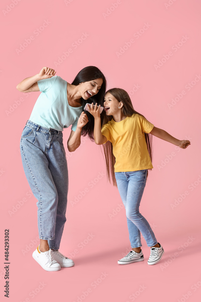 快乐的跳舞女人和她的女儿在彩色背景上