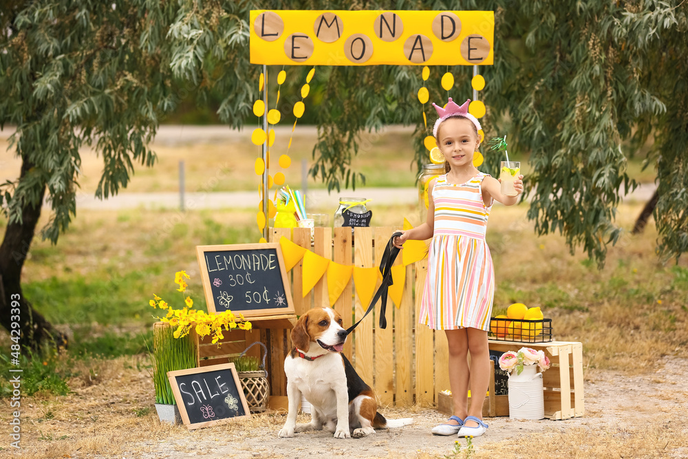 Cute girl with dog near lemonade stand in park