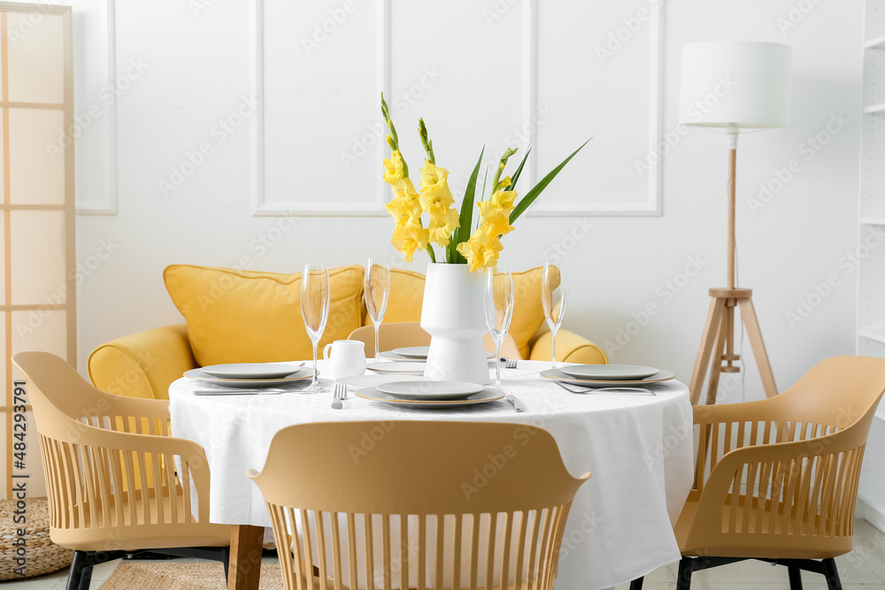 Beautiful served table with Gladiolus flowers in light room