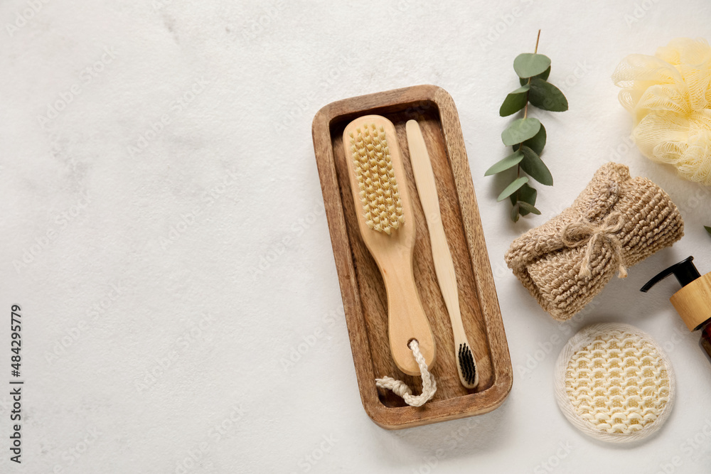 Different bath supplies and eucalyptus branch on light background