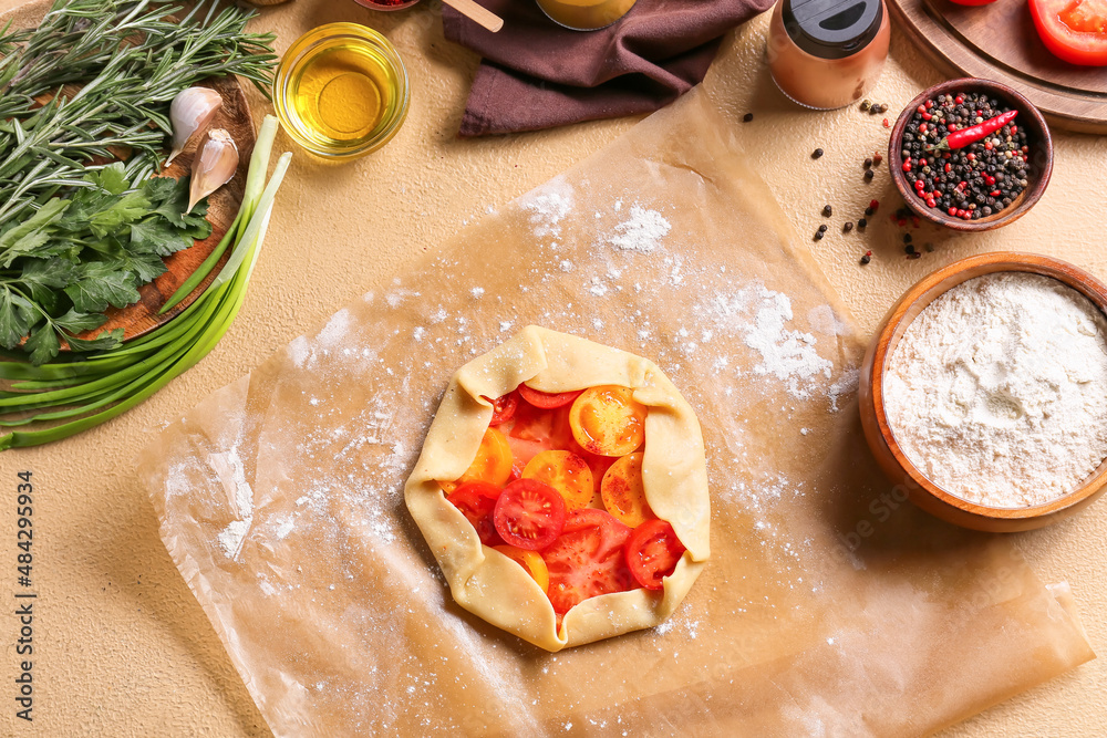 Raw dough for tasty tomato galette at table