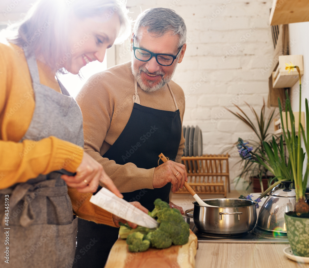 happy elderly married couple   cooking a delicious and healthy   lunch together in a cozy kitchen