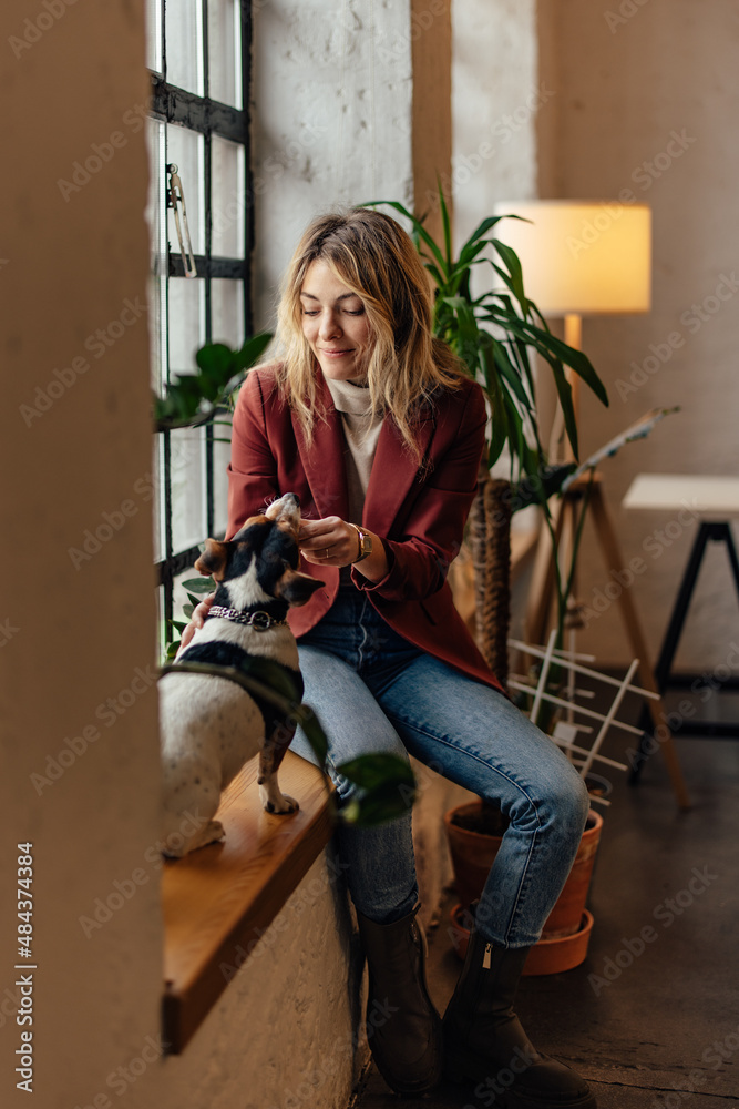 Beautiful girl spending time with her dog, during breaks from online work.