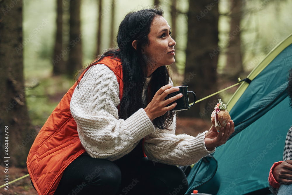 Woman eating with friends at their camp