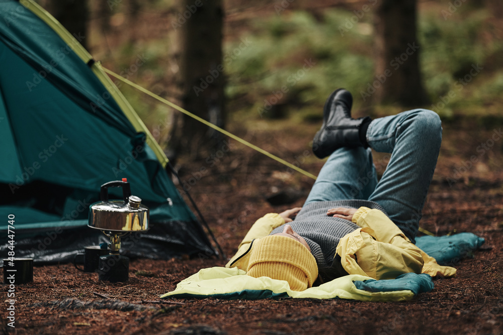 Woman lying on her sleeping bag outdoors