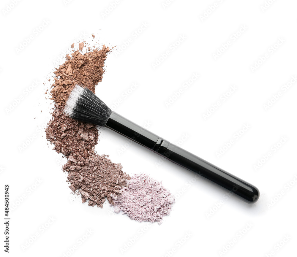 Makeup brush and loose eye shadow on white background