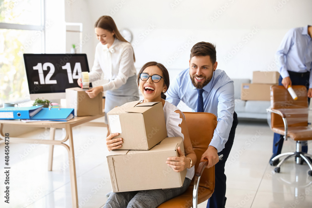 Business colleagues having fun while packing things in office on moving day