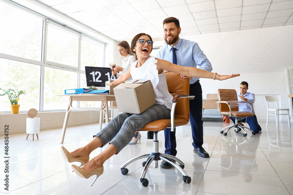 Business colleagues having fun while packing things in office on moving day