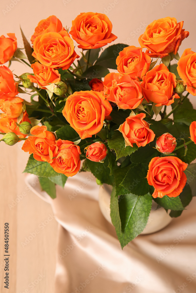 Vase with beautiful orange roses on table, closeup