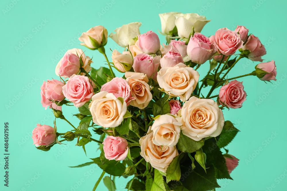 Bouquet of beautiful small roses on green background