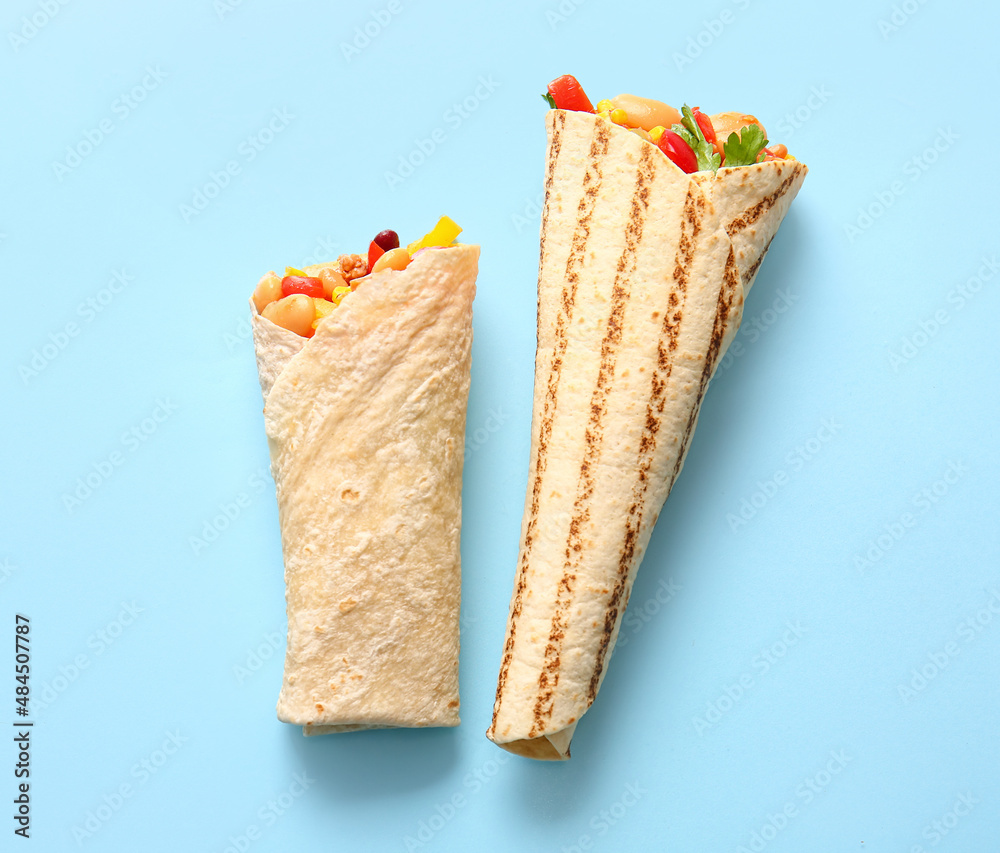 Delicious burritos on blue background