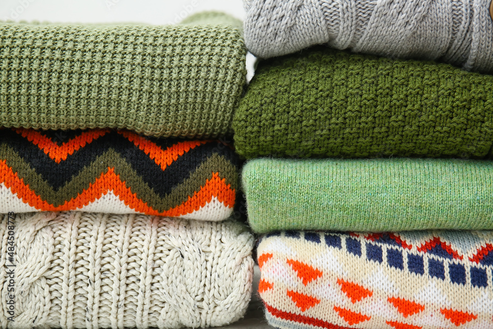 Stacks of stylish sweaters, closeup