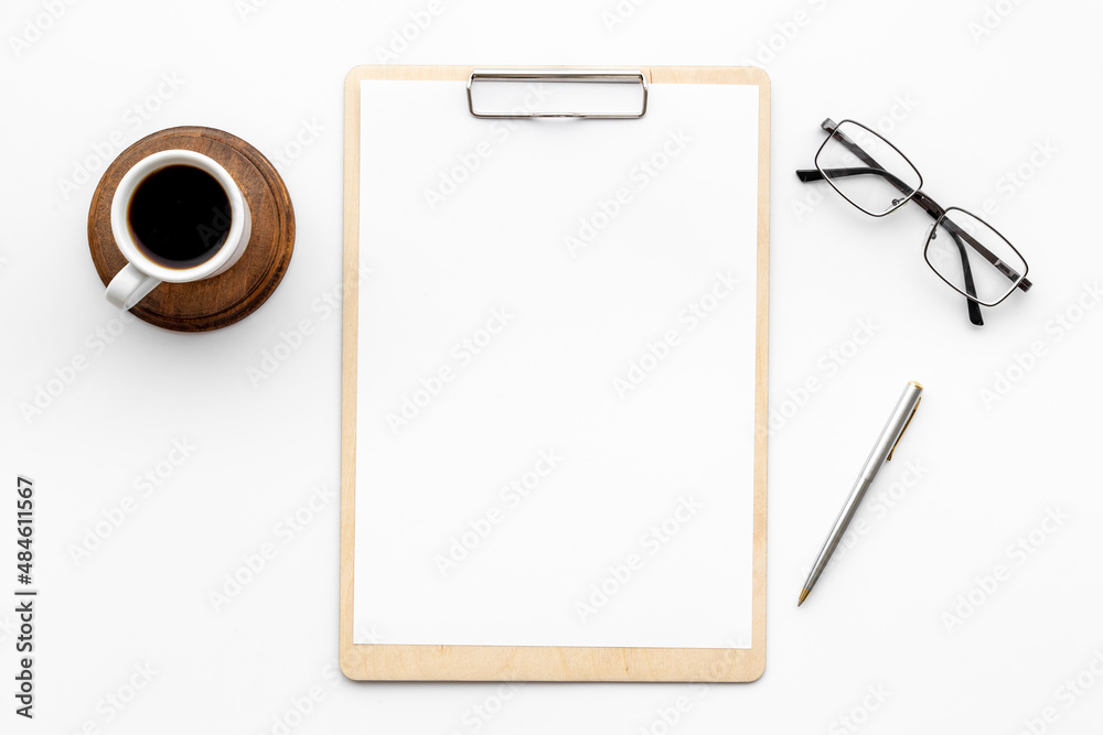 White office desk table with empty paper on clipboard