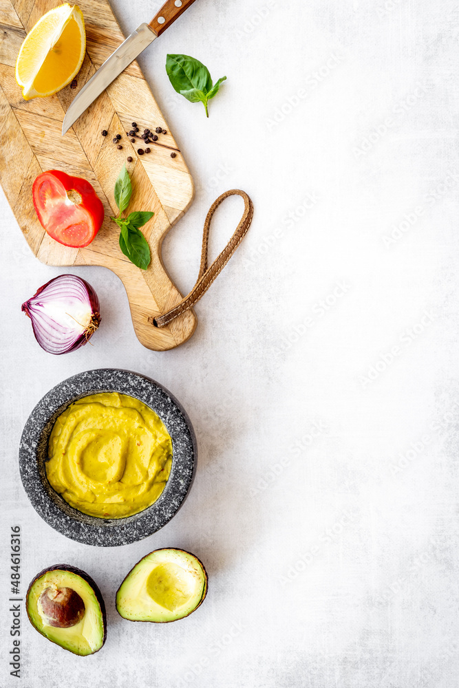 Homemade guacamole avocado dip in mortar with ingredients