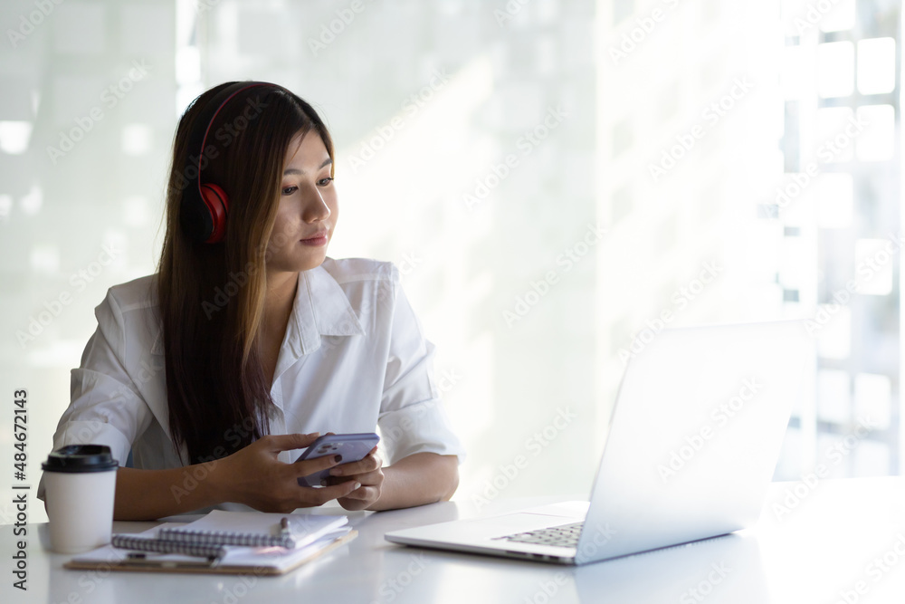 Woman working on laptop in white office in the morning. Woman looking at laptop screen having online