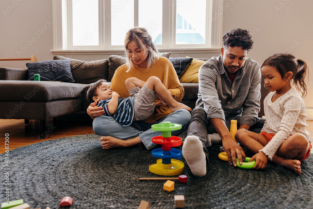 Mom and dad playing with their kids at home