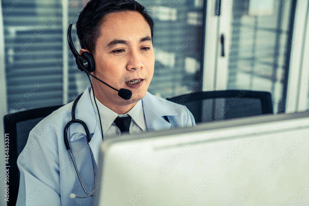 Doctor wearing headset talking actively on video call in a clinic or hospital . Concept of telehealt