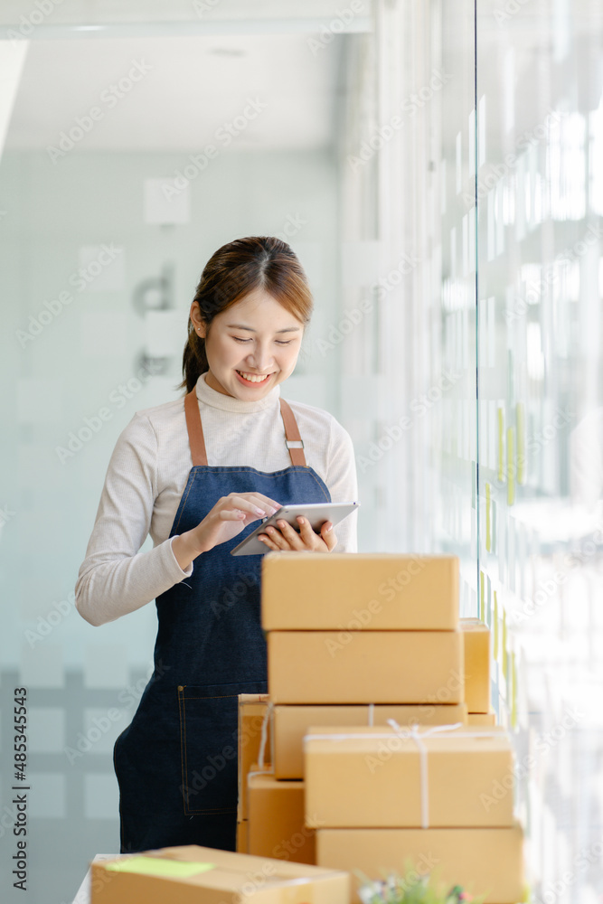 自由职业女性微笑着检查准备发货的产品库存