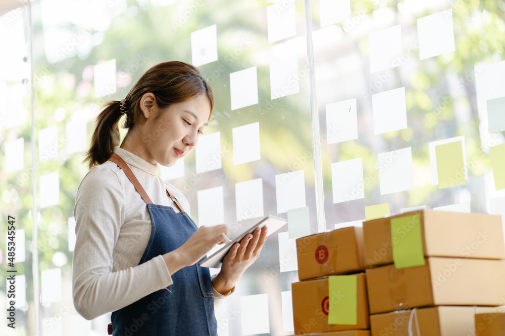 Working woman sme business at office in home interior her checking order from tablet for customer an