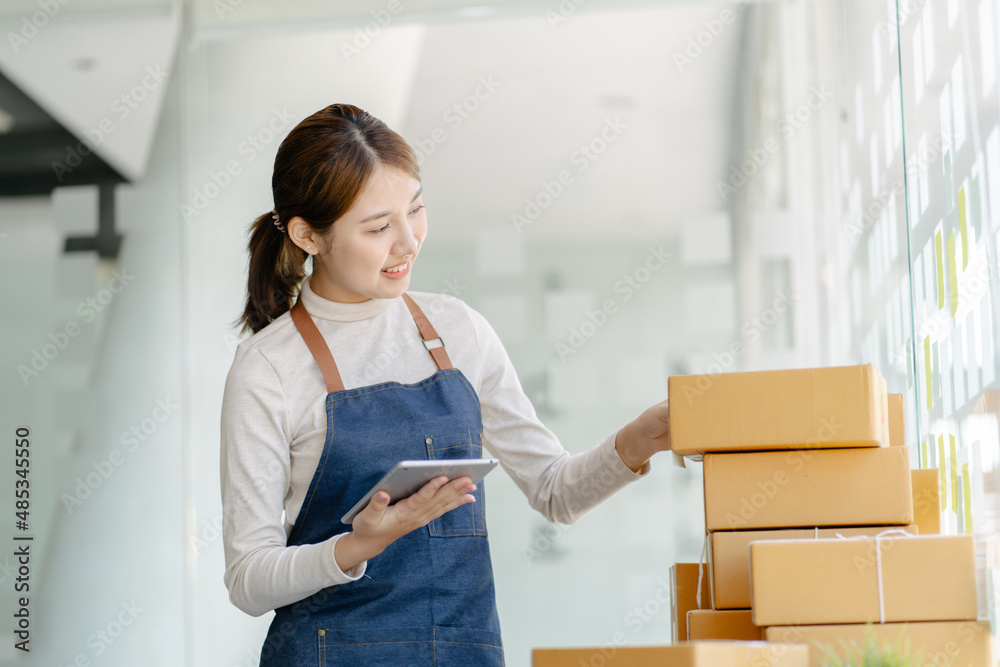 Working woman sme business at office in home interior her checking order from tablet for customer an