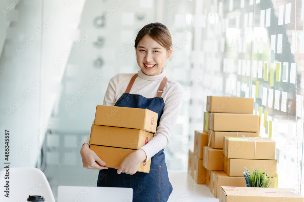 Portrait beautiful young asian woman with box ready for shipping on color background