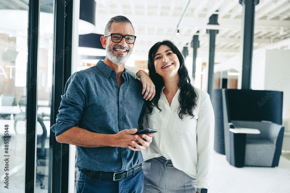 Businesspeople smiling at the camera in an office