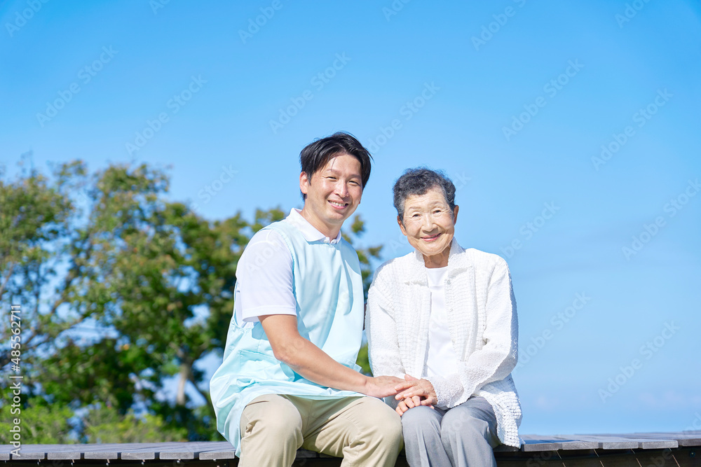 介護士と高齢者　屋外