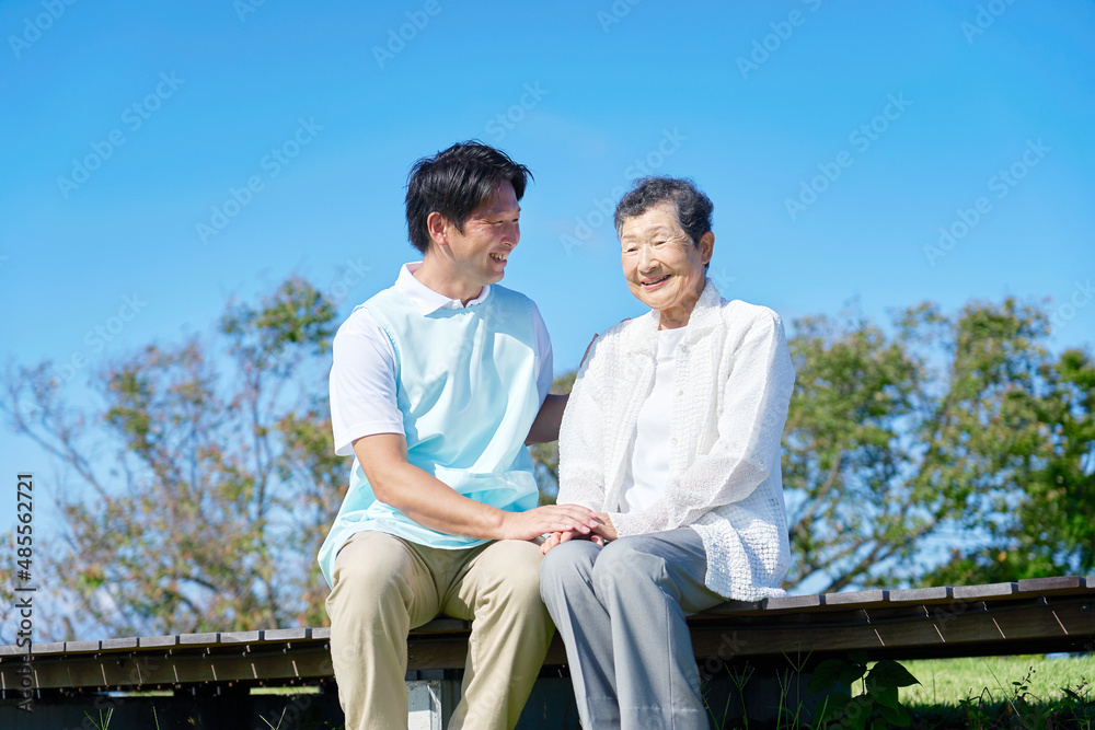 介護士と高齢者　屋外