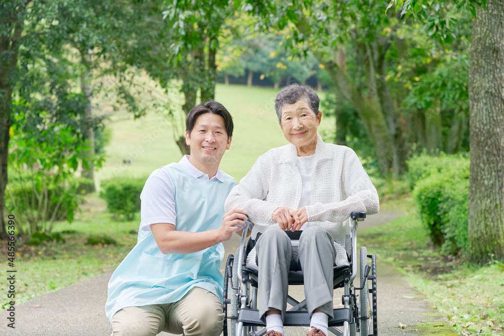 介護士と車椅子に乗る高齢者　屋外ポートレート