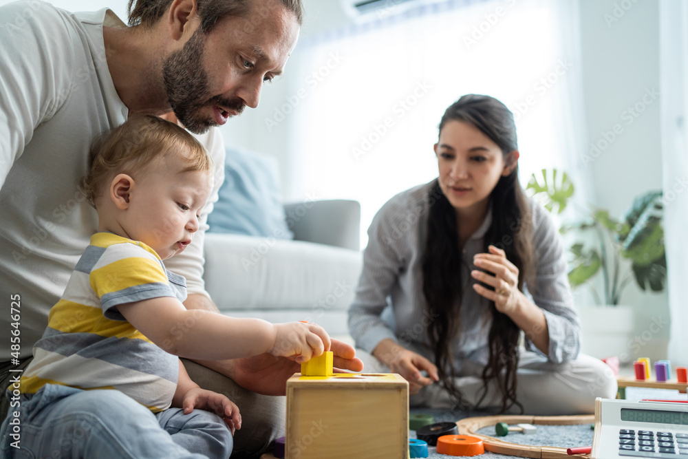 Caucasian happy loving parent play with baby toddler in living room. 