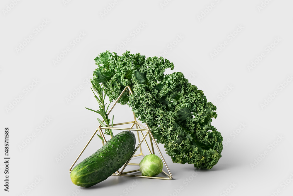 Composition with green vegetables on light background