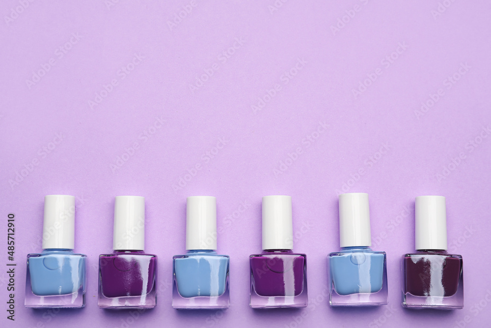 Set of nail polish bottles on color background