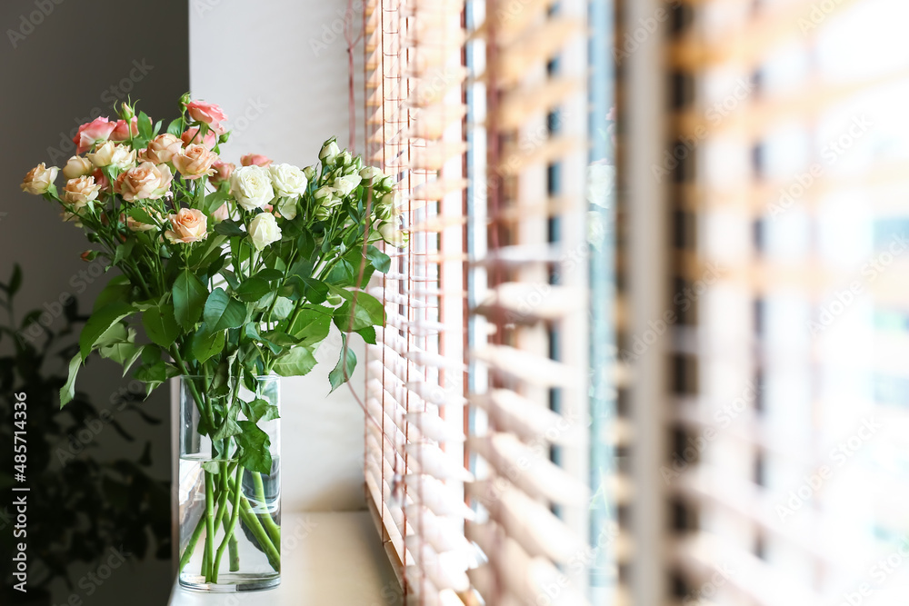 Vase with bouquet of beautiful fresh roses on windowsill