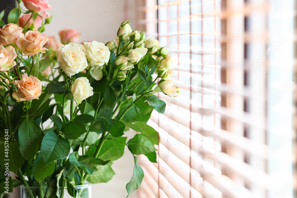 Vase with bouquet of beautiful fresh roses near window, closeup