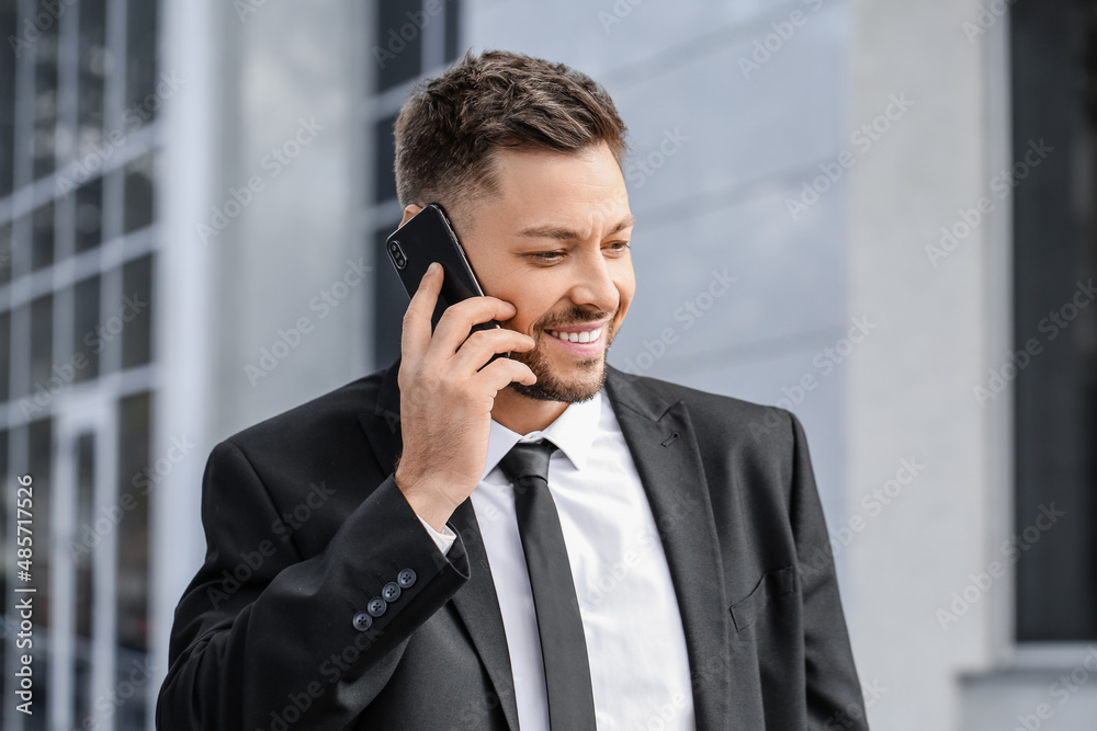 Stylish businessman talking by mobile phone near office building, closeup