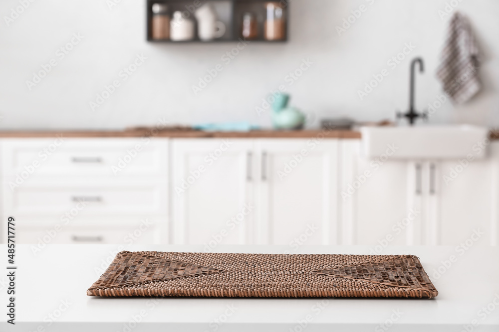 Wicker mat on white table in kitchen