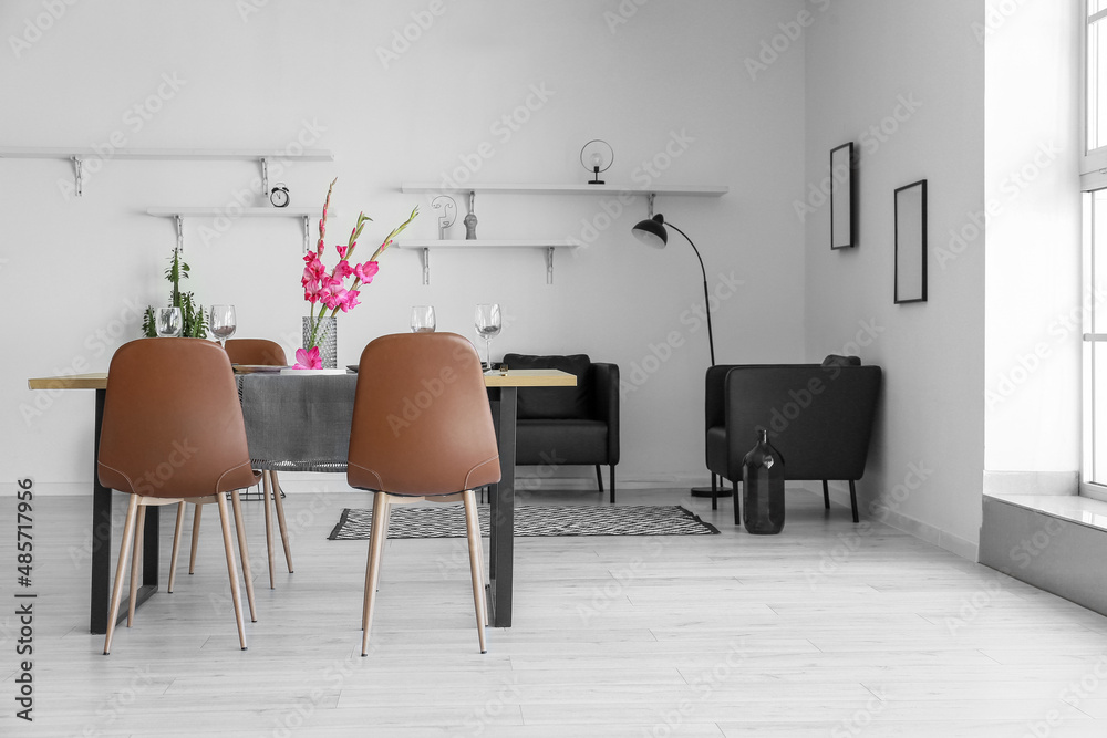 Interior of stylish room with beautiful table setting and Gladiolus flowers