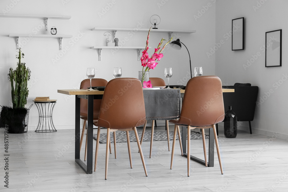 Interior of stylish room with beautiful table setting and Gladiolus flowers