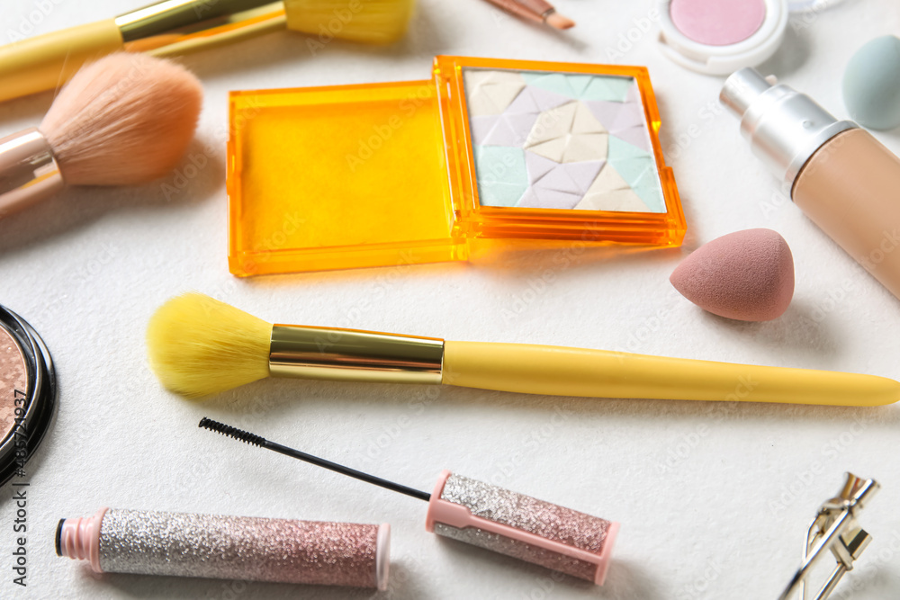 Different makeup products on light background, closeup