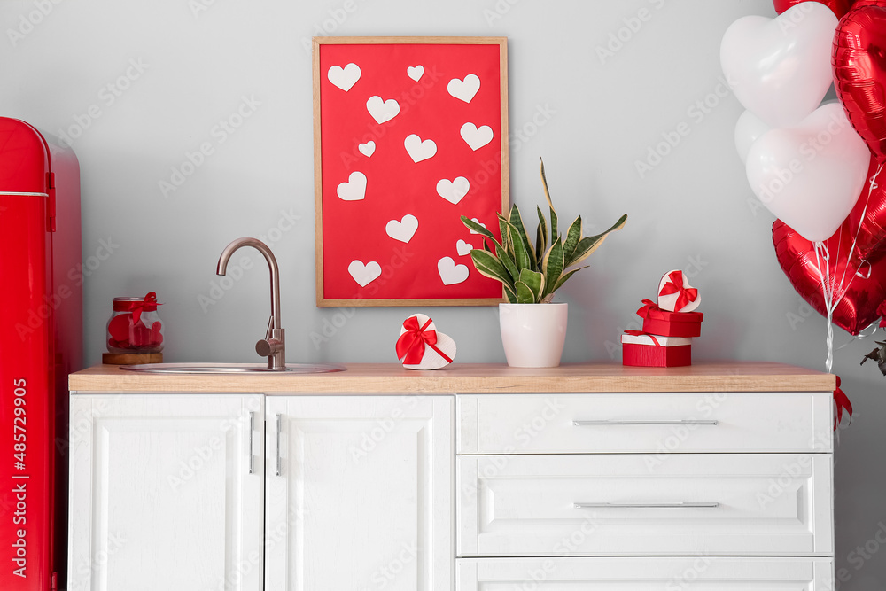 Counters with houseplant, gift boxes and stylish decor for Valentines Day celebration in kitchen