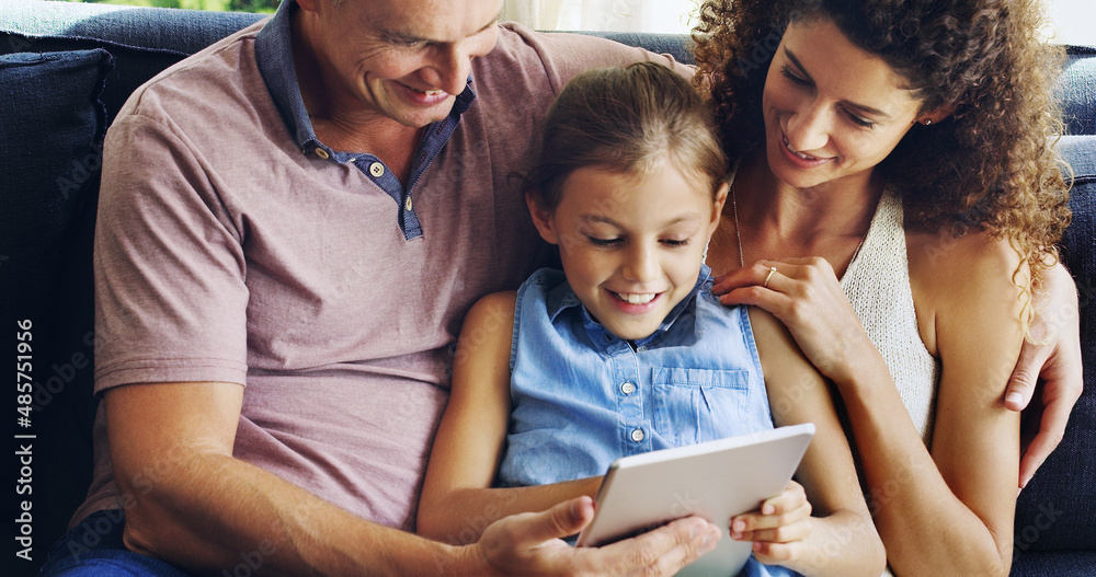 Family time just got even more fun. Shot of a cute little girl using a digital tablet with her mothe