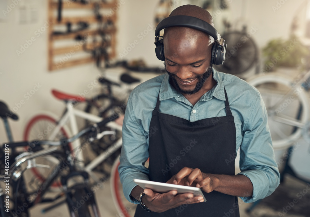 We need good music in this store. Shot of a handsome young man standing alone in his bicycle shop an