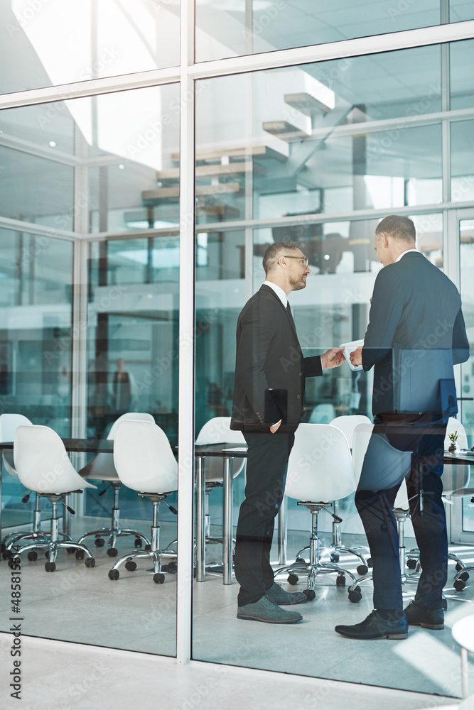 Let me take a look. Full length shot of two corporate businessmen meeting in the boardroom.