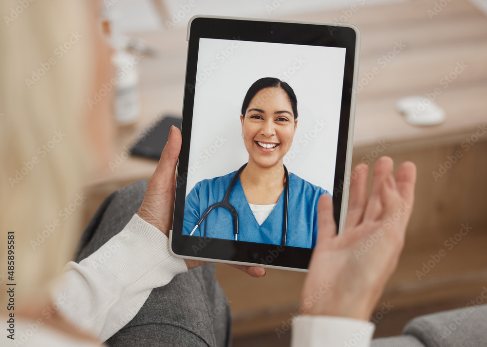 A wireless bridge between doctor and me. Shot of a mature woman using a digital tablet to have a vid