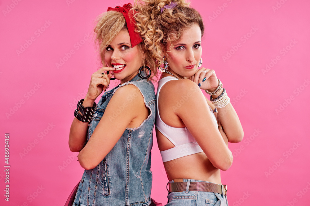 Bad girls have all the fun. Studio shot of two beautiful young women styled in 80s clothing.