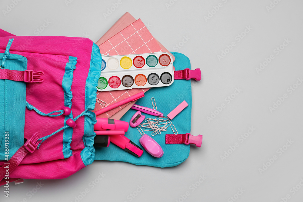 School backpack with different stationery on white background