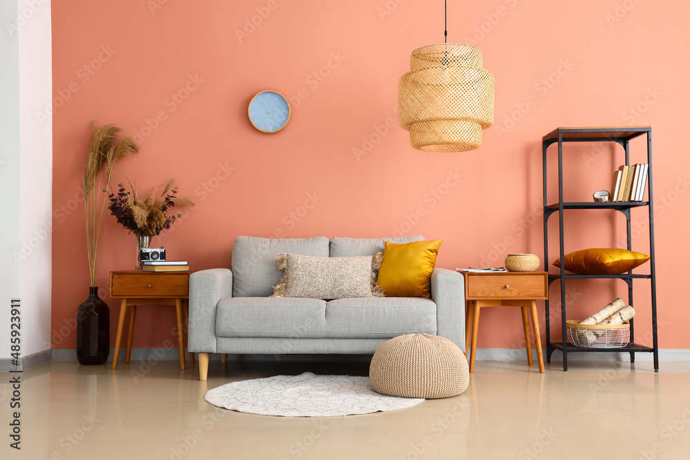 Interior of stylish living room with sofa, wooden tables and shelving unit