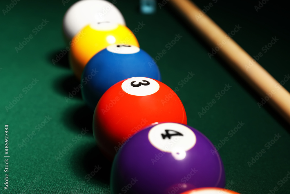 Different billiard balls on green table, closeup