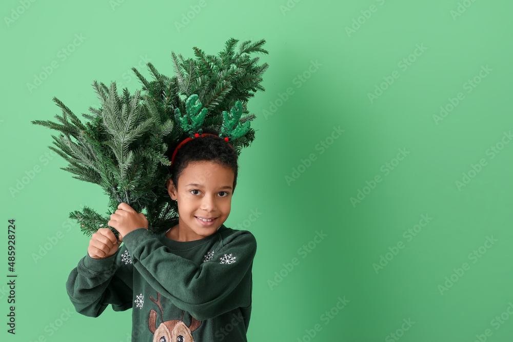 Cute little African-American boy with Christmas tree on color background